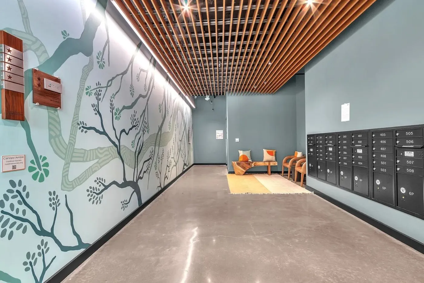 Capitol lobby with botanical mural, wood-slat ceiling and mailboxes