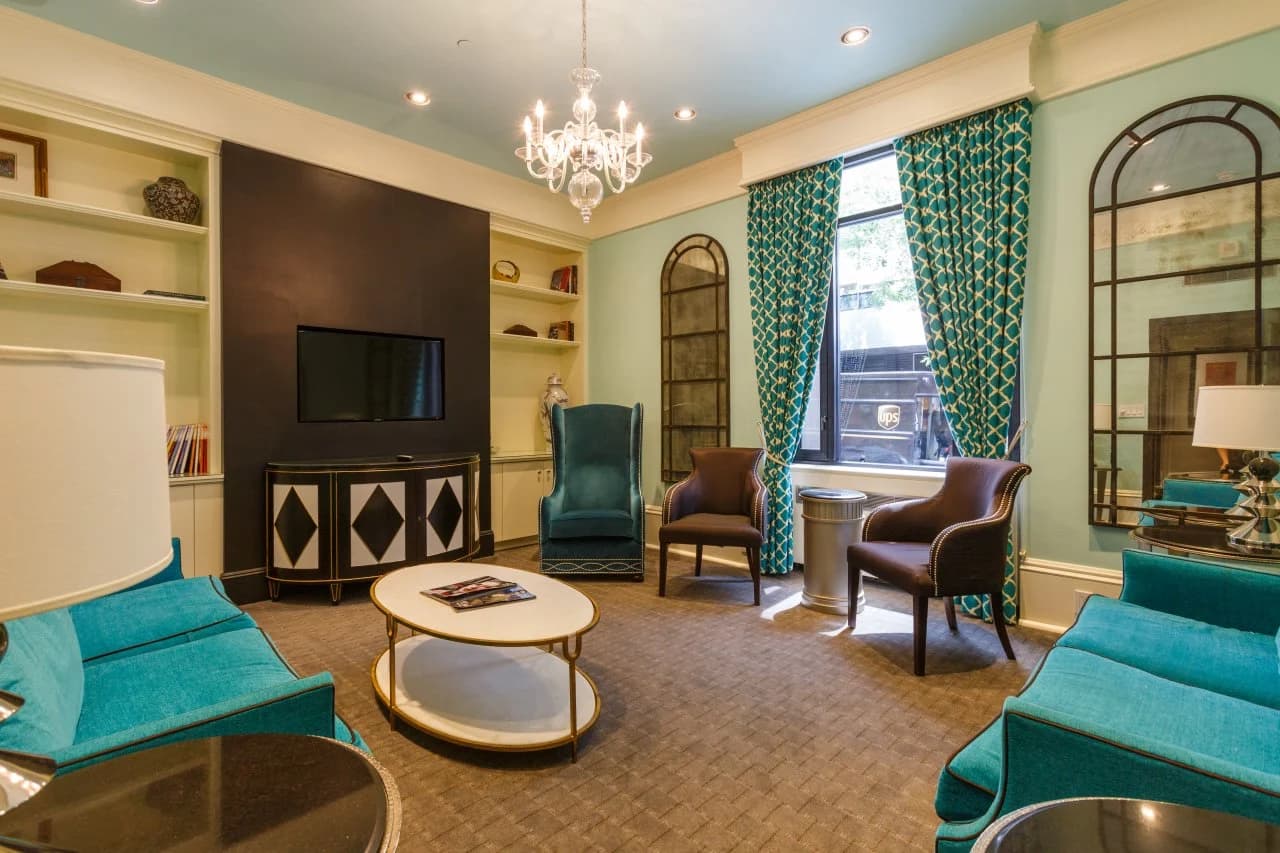 Seton lounge with teal armchairs and chandelier